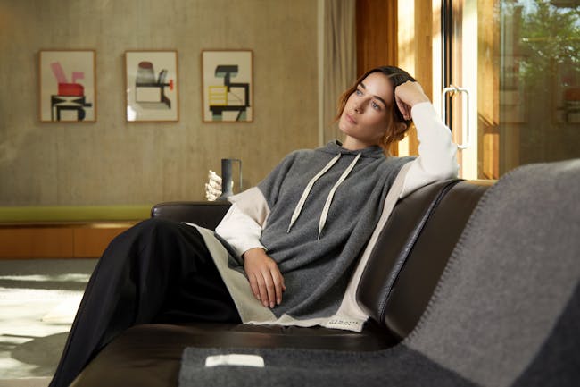 A woman sitting on top of a couch next to a window