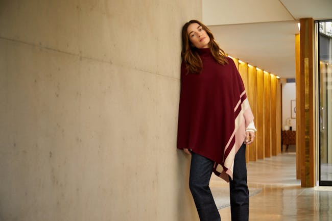 A woman leaning against a wall in a hallway