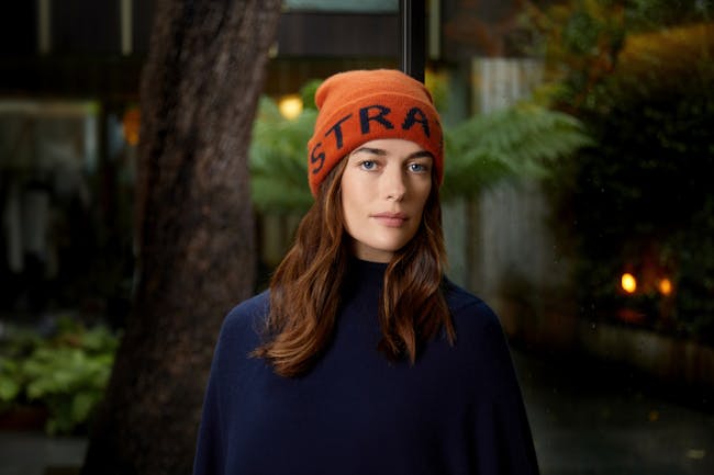 A woman wearing a hat with the word stra on it