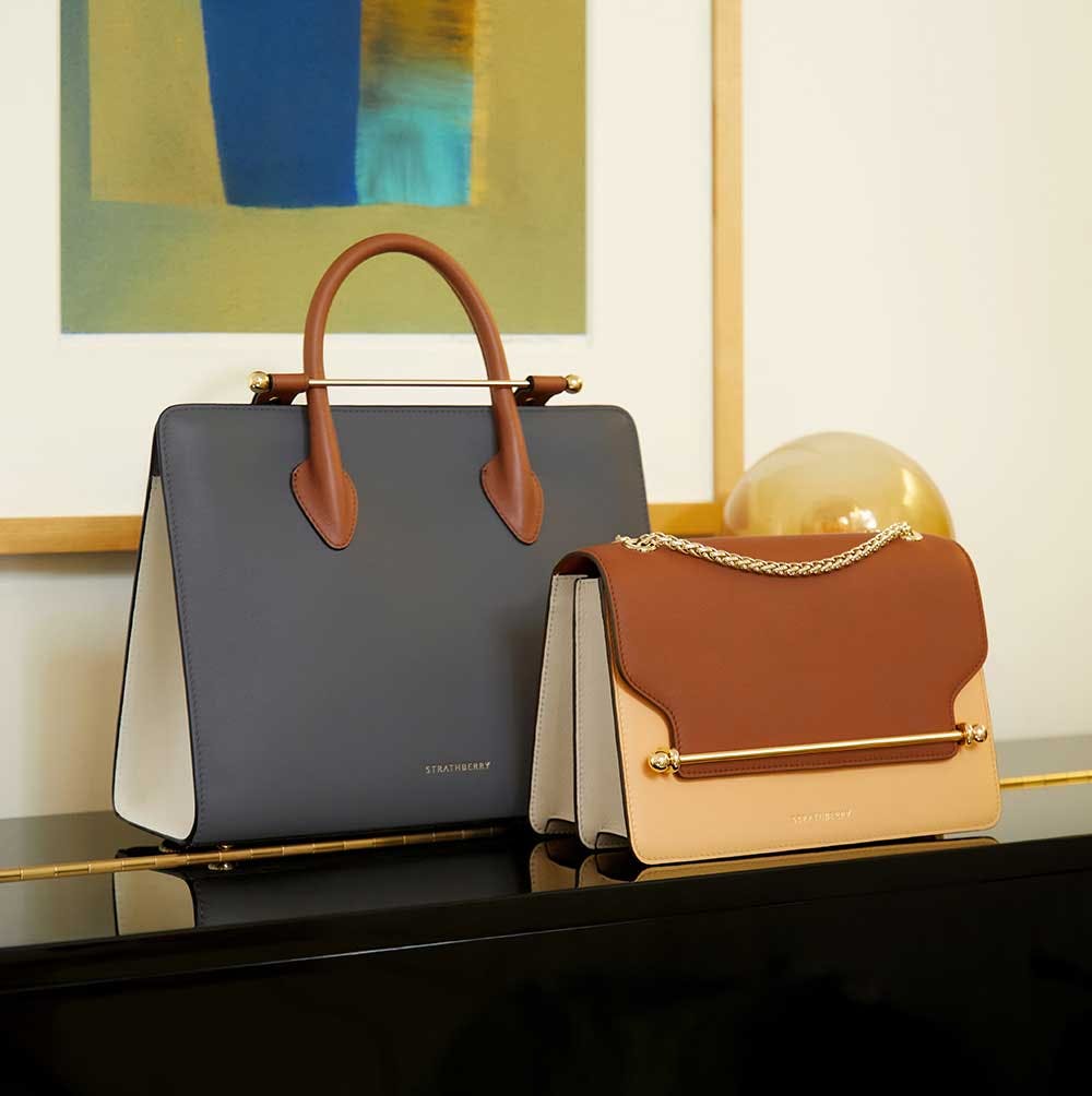 Two purses sitting on top of a black table