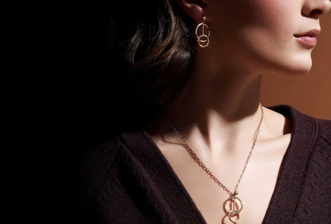 A woman wearing a necklace and earrings