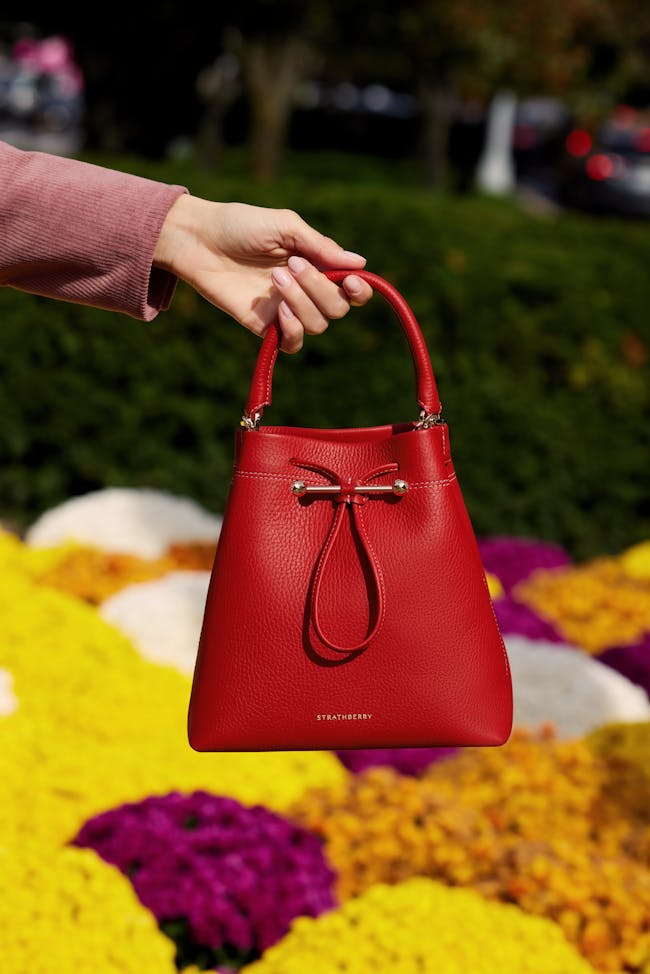 A woman's hand holding a red purse