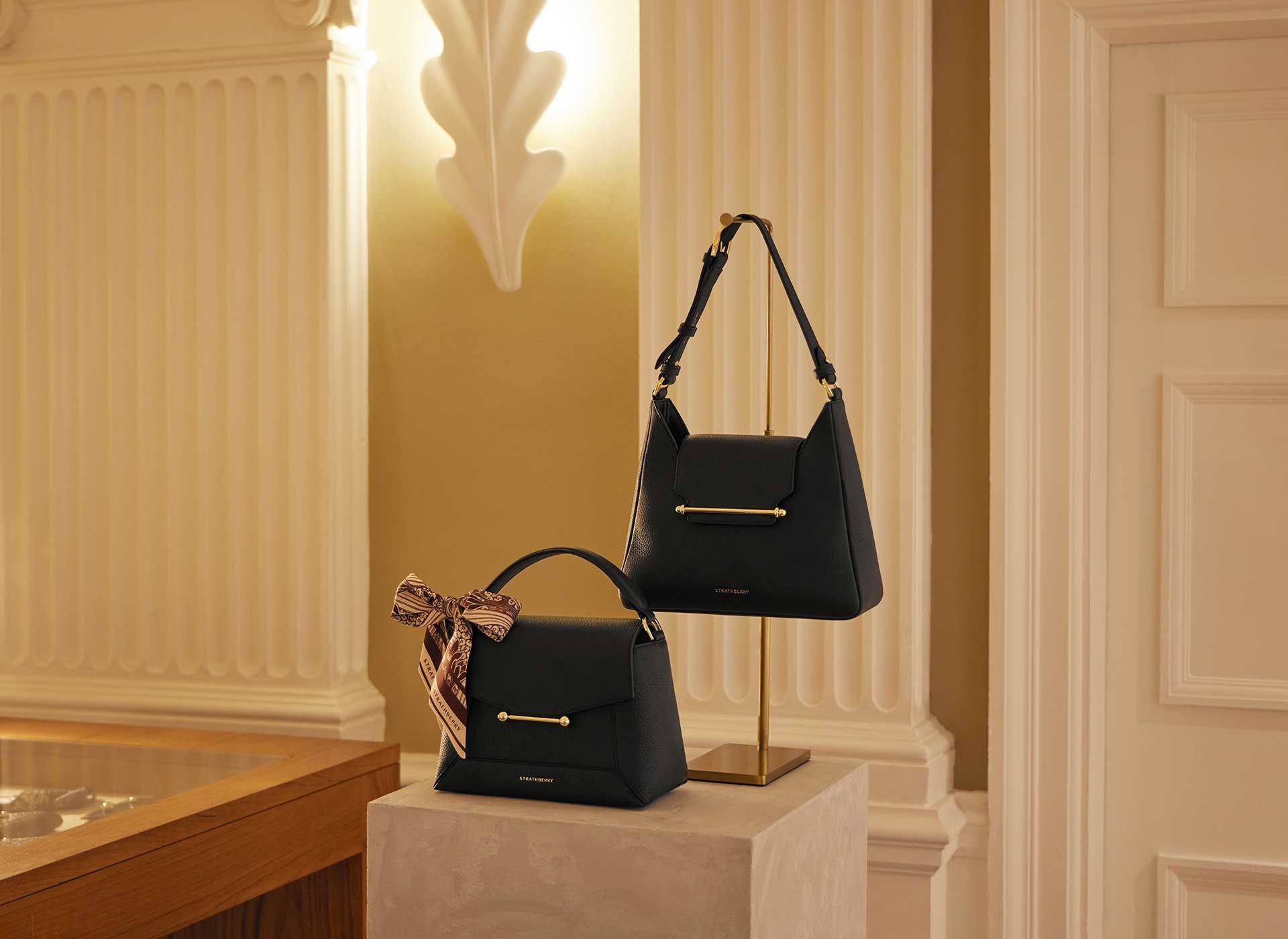 A pair of black purses sitting on top of a table