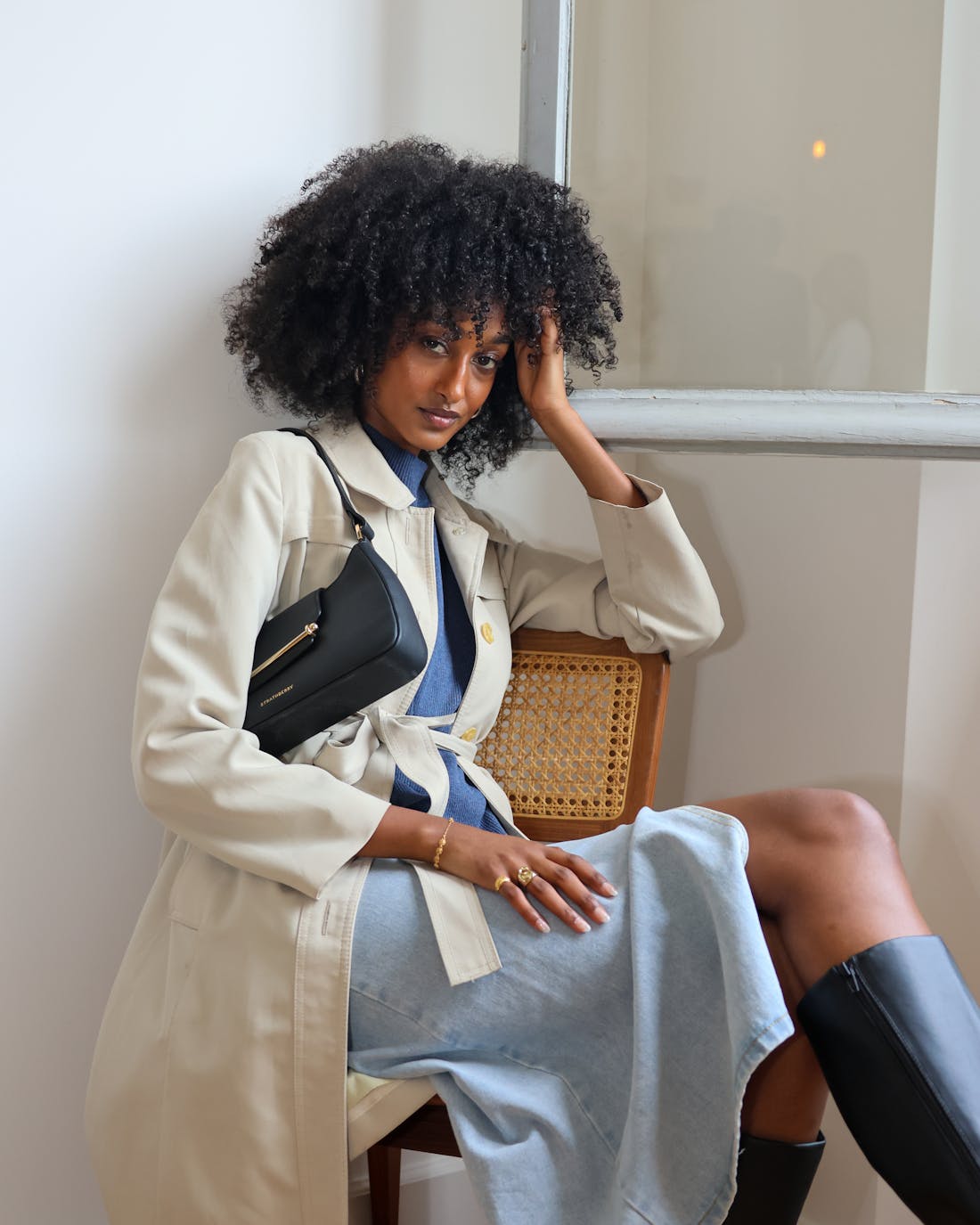 A woman sitting on a chair with her hand on her head