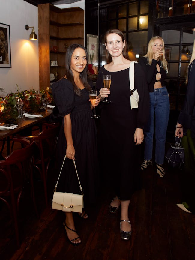Two women standing next to each other holding wine glasses