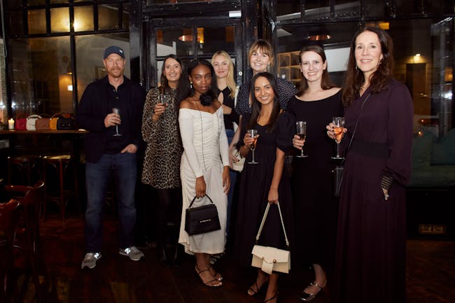 A group of people standing next to each other holding wine glasses
