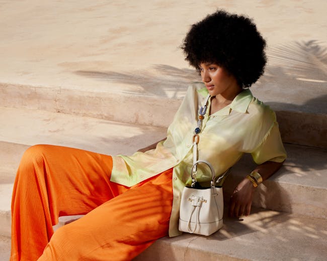 A woman sitting on the steps with a handbag