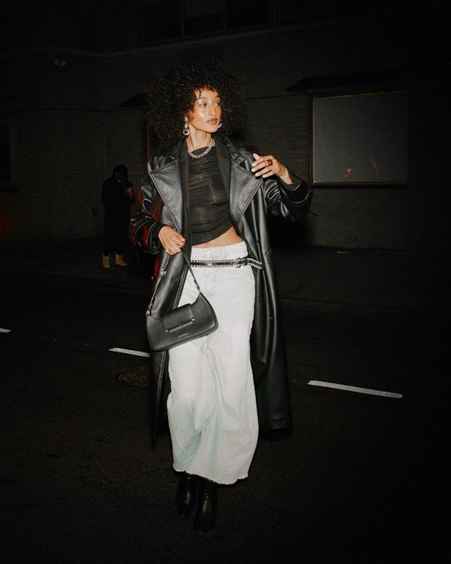 A woman walking down a street at night