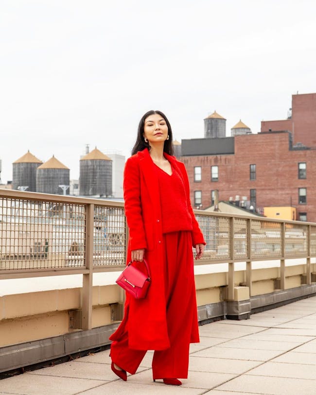 A woman in a red outfit is standing on a bridge