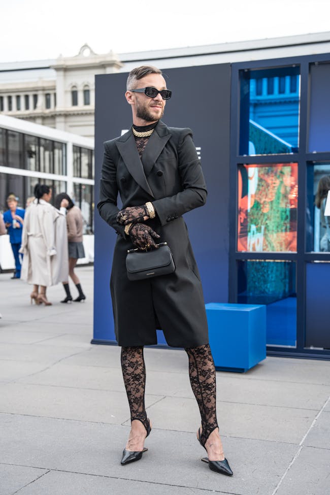 A man in a black coat and patterned tights