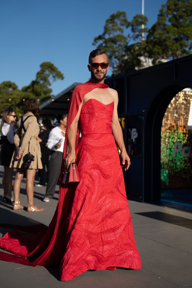 A woman in a red dress is walking down the street