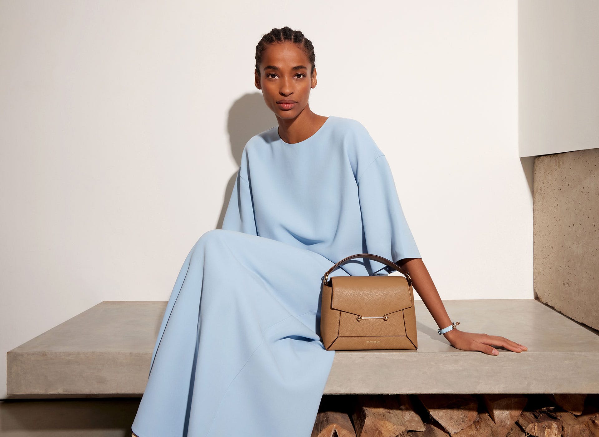 A woman sitting on a bench with a handbag