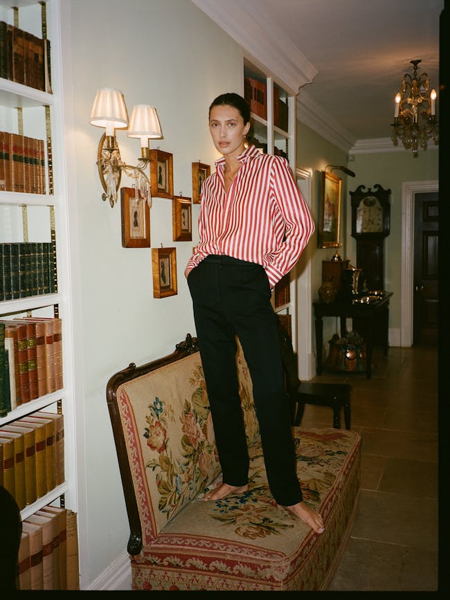A woman standing on a couch in a room