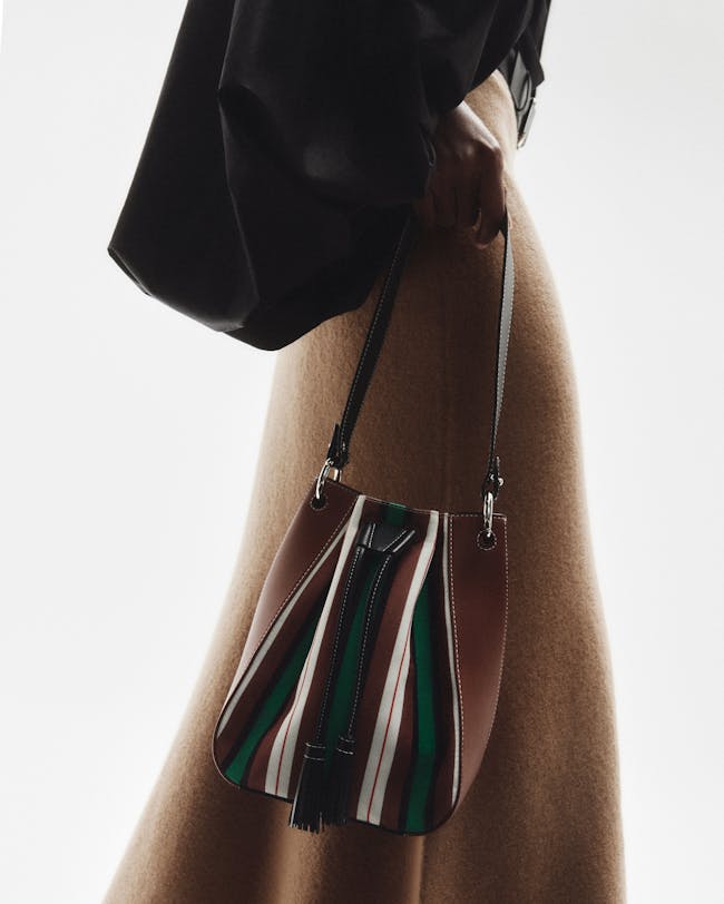 A woman is holding a striped purse