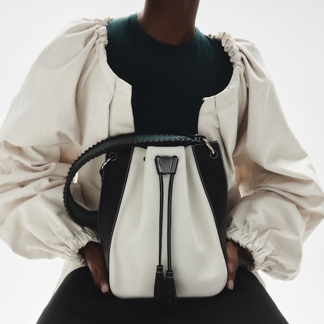 A woman holding a white and black purse