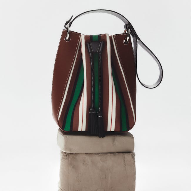 A brown and green purse sitting on top of a block