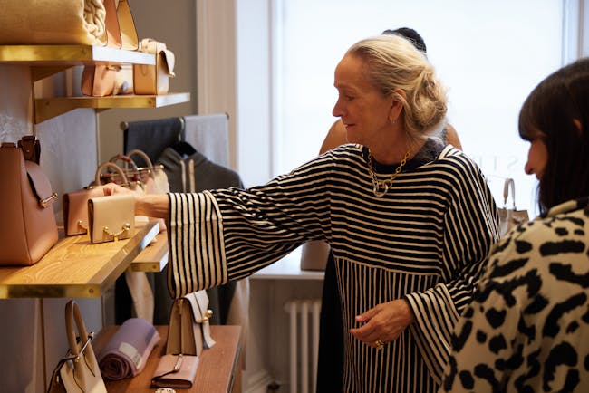 A woman looking at handbags on a shelf