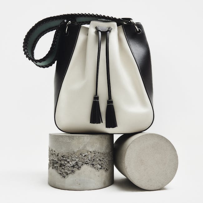 A white and black purse sitting on top of a cement block