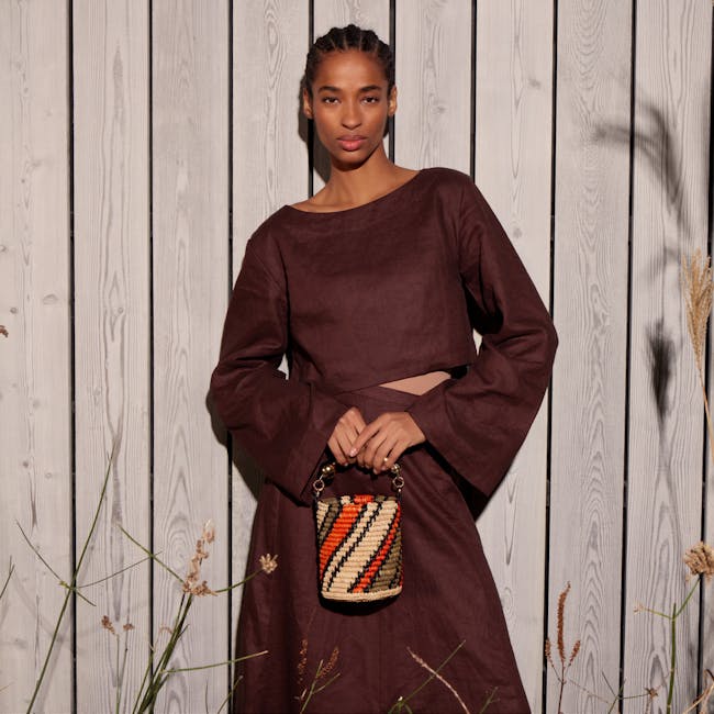 A woman standing in front of a wooden fence