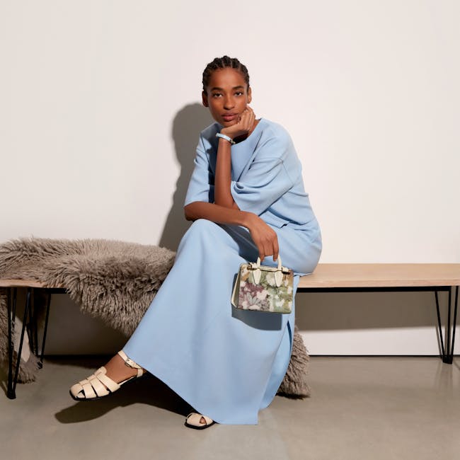 A woman sitting on a bench holding a purse