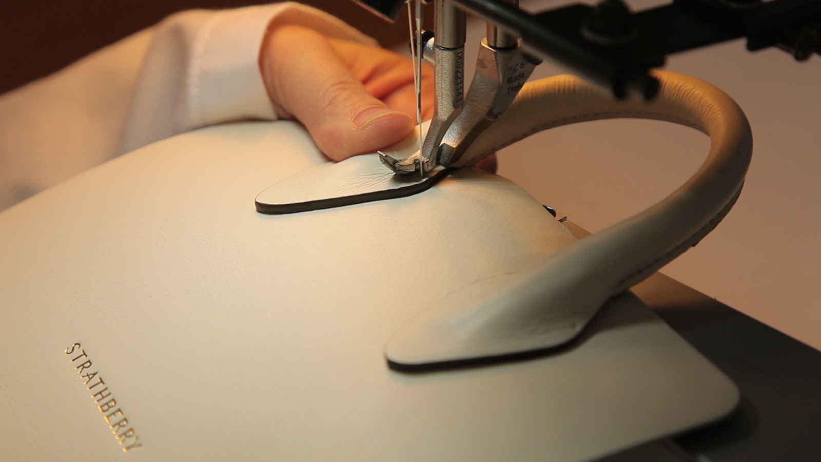 A person using a pair of scissors to cut a piece of fabric