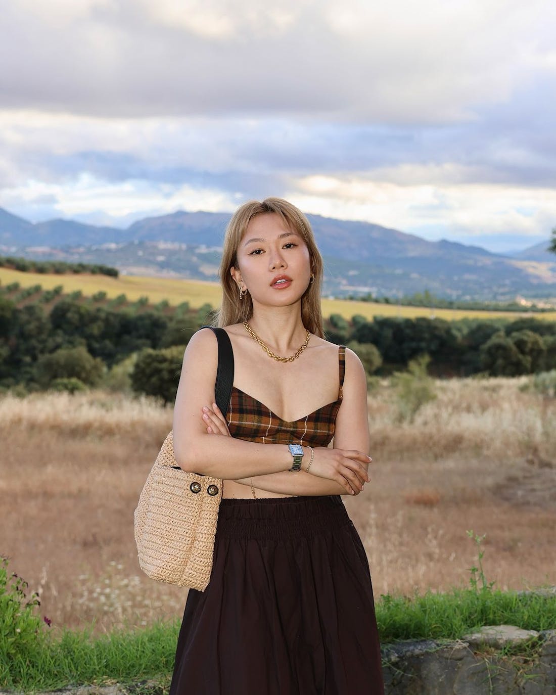 Influencer Andrea Cheong in Ubrique, Spain wearing a Strathberry Lana Hobo handbag in Raffia with black leather strap.