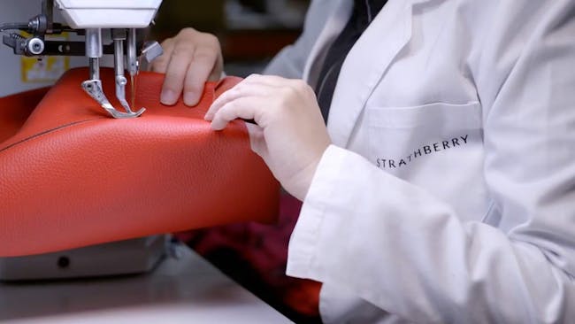 A woman is working on a red bag