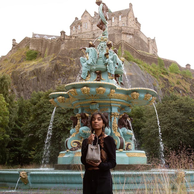 A woman standing in front of a fountain with a castle in the background