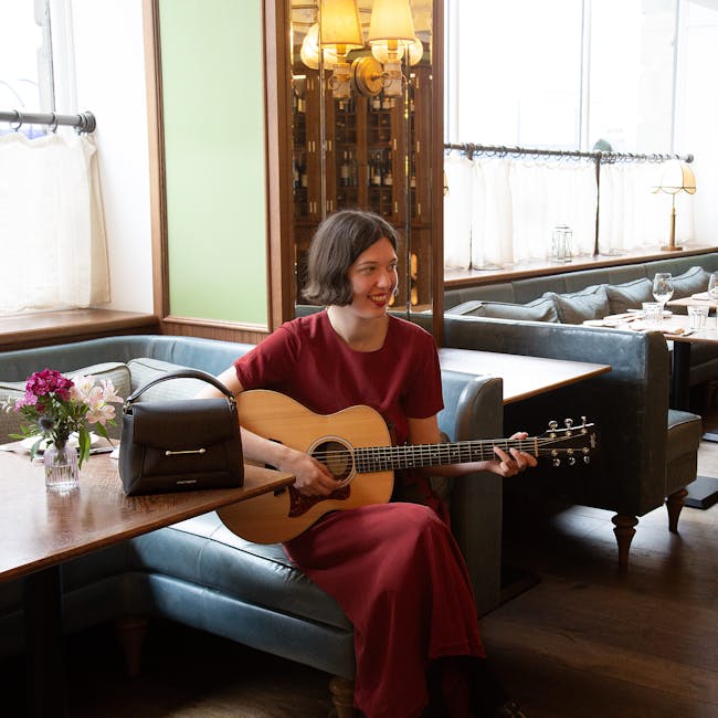 A woman sitting at a table with a guitar