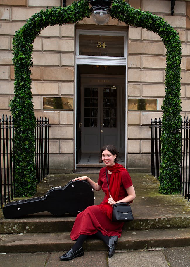 A woman sitting on the steps with a suitcase