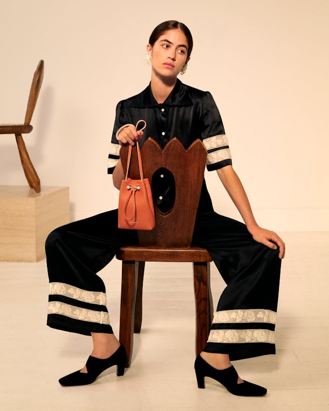 A woman sitting on a chair holding a purse
