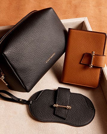 A pair of black and brown purses sitting on top of a white box