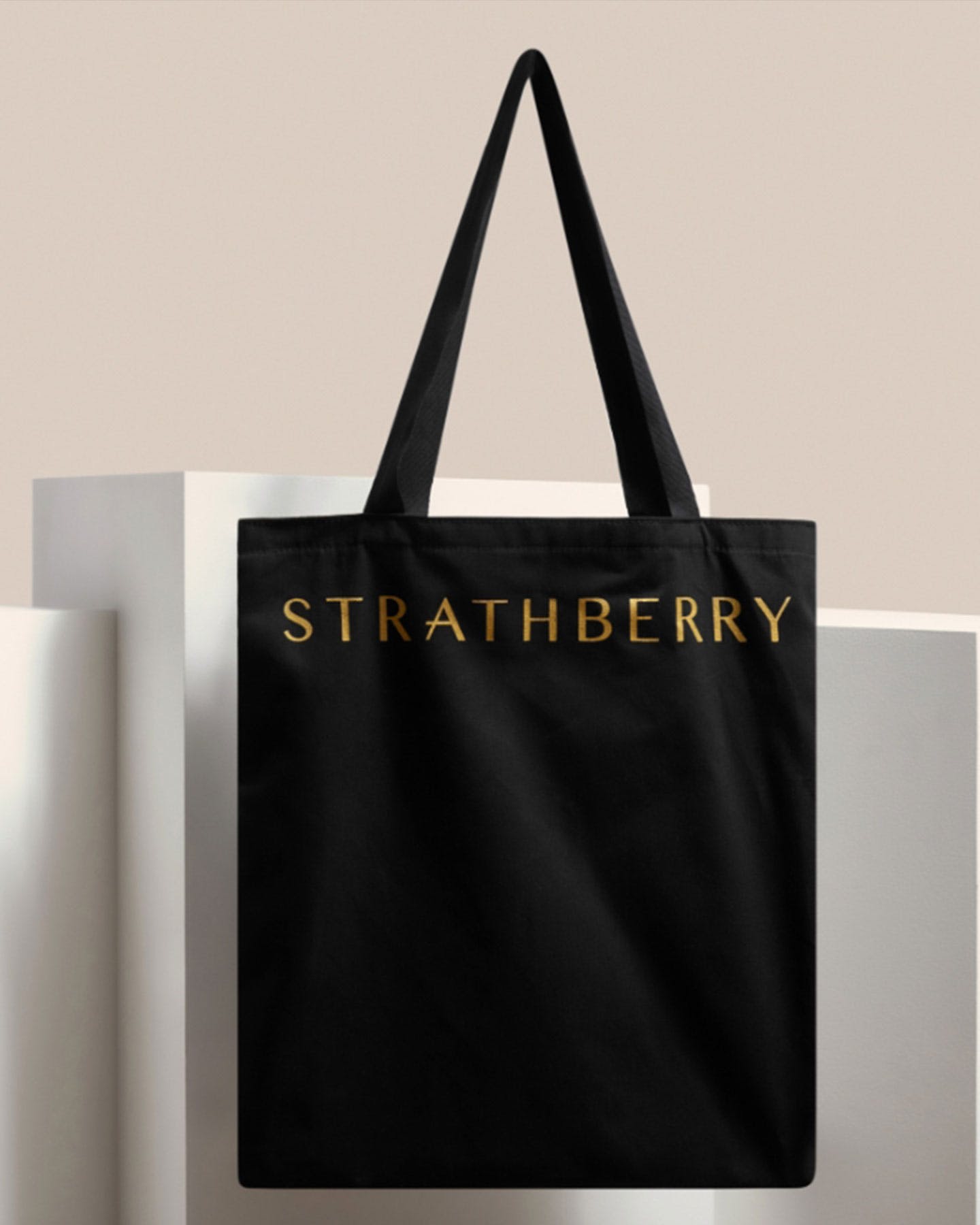 A black tote bag hanging from a wall