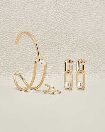 A pair of gold earrings and a pair of pearls