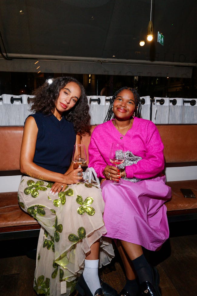 Two women sitting next to each other on a bench