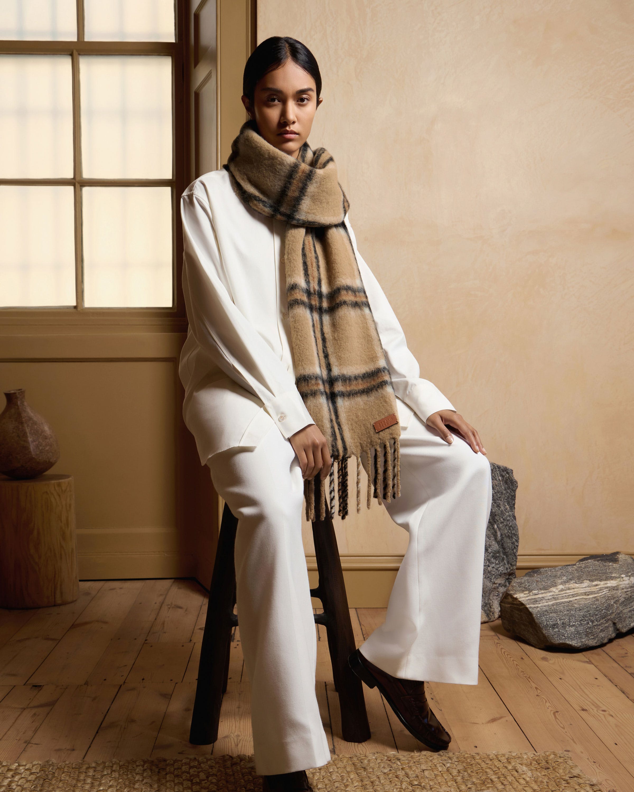 A woman sitting on a chair wearing a scarf