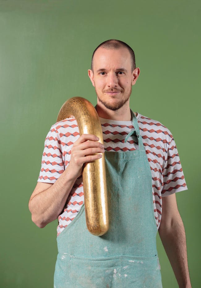 A man holding a large golden object in his hands