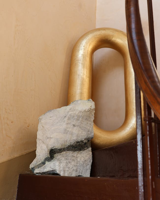 A rock sitting on top of a wooden step