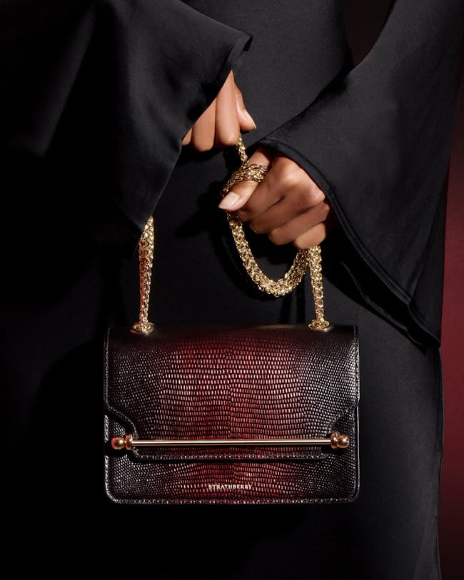 A woman's hand holding a brown purse