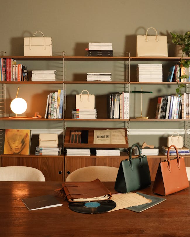 A wooden table topped with bags and books