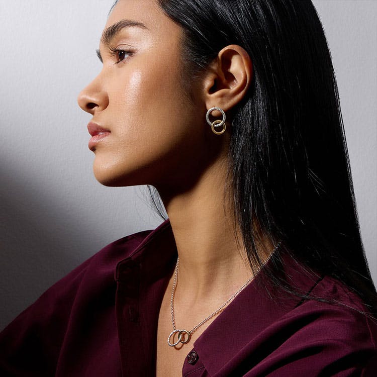 A woman wearing silver earrings and a necklace