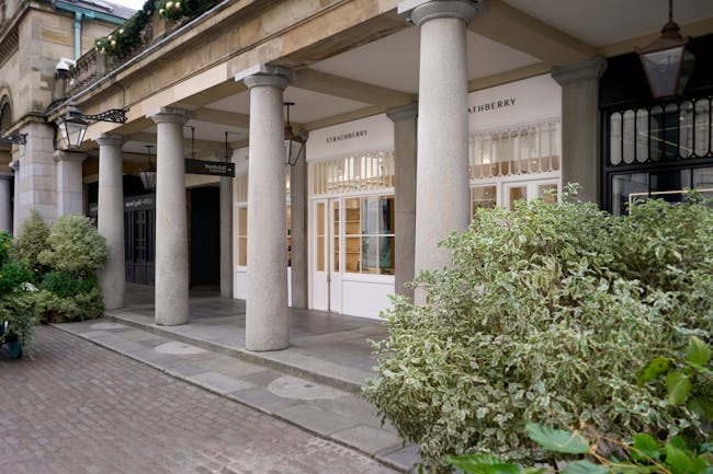 A building with columns and plants in front of it