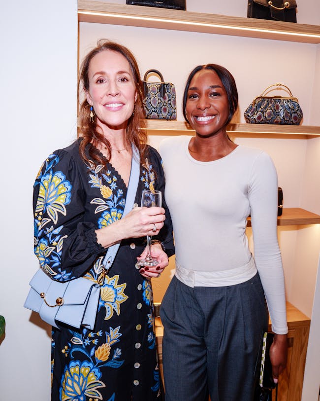 Two women standing next to each other holding wine glasses