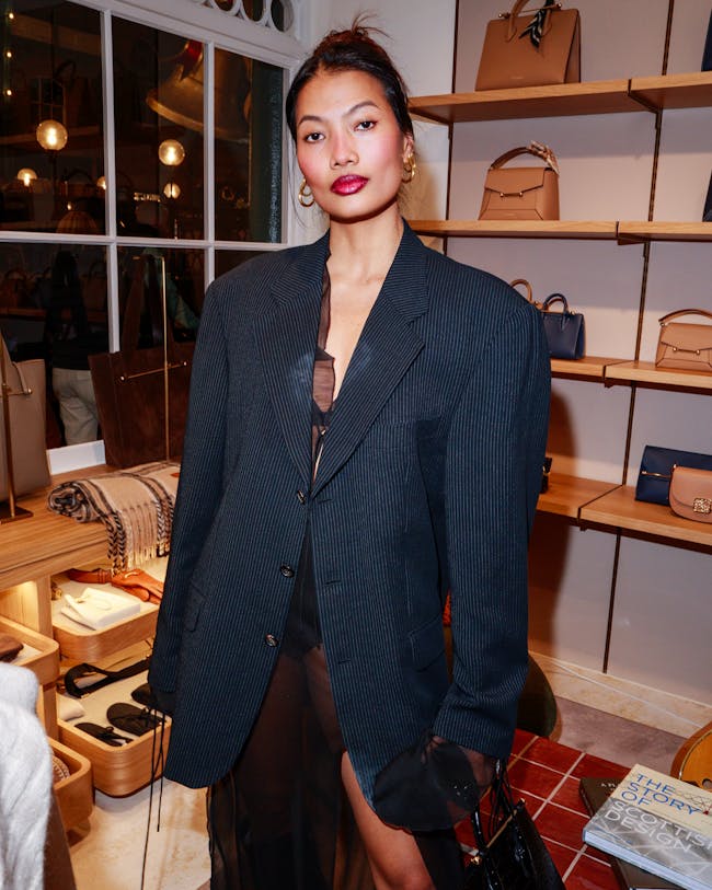 A woman standing in front of a display of purses