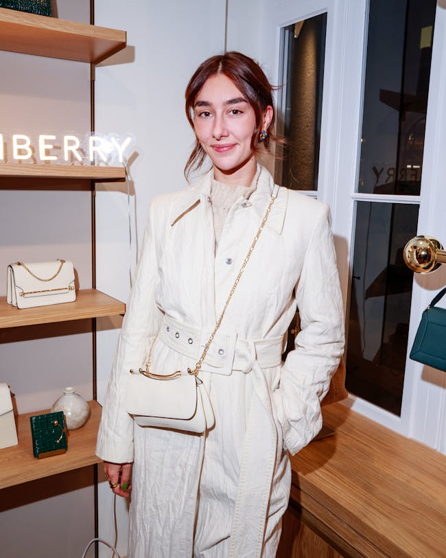A woman standing in front of a display of purses