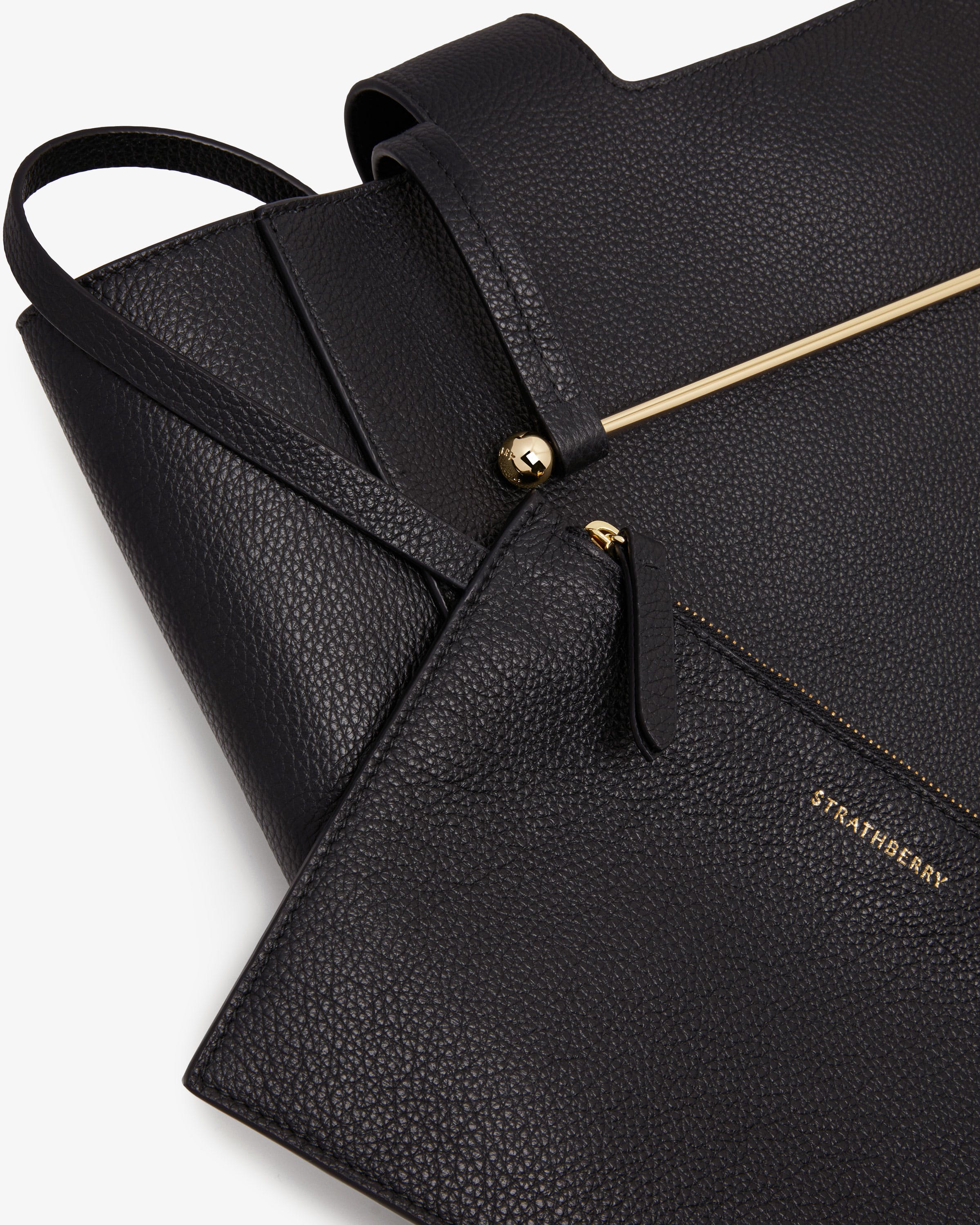 A black leather purse with a gold zipper