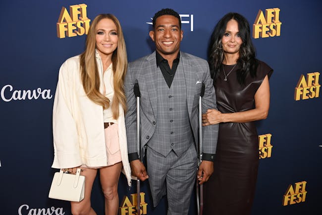 Three people standing next to each other on a red carpet