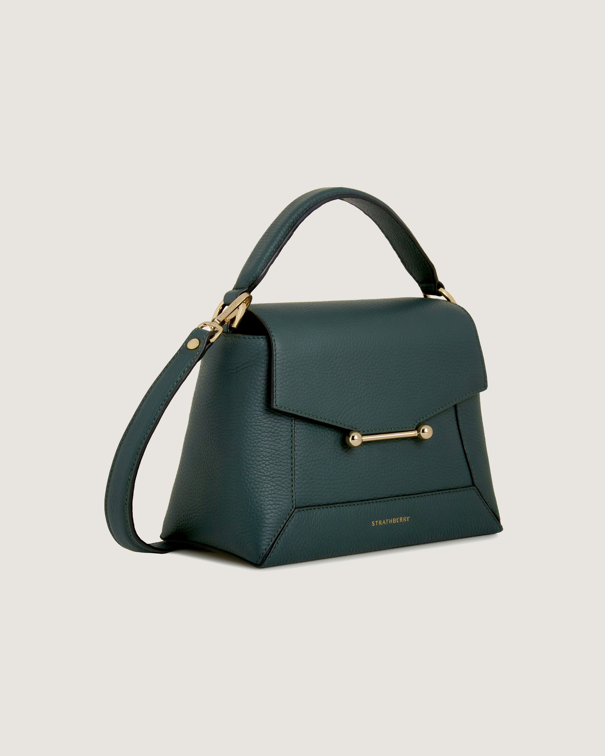 A green handbag with a gold handle