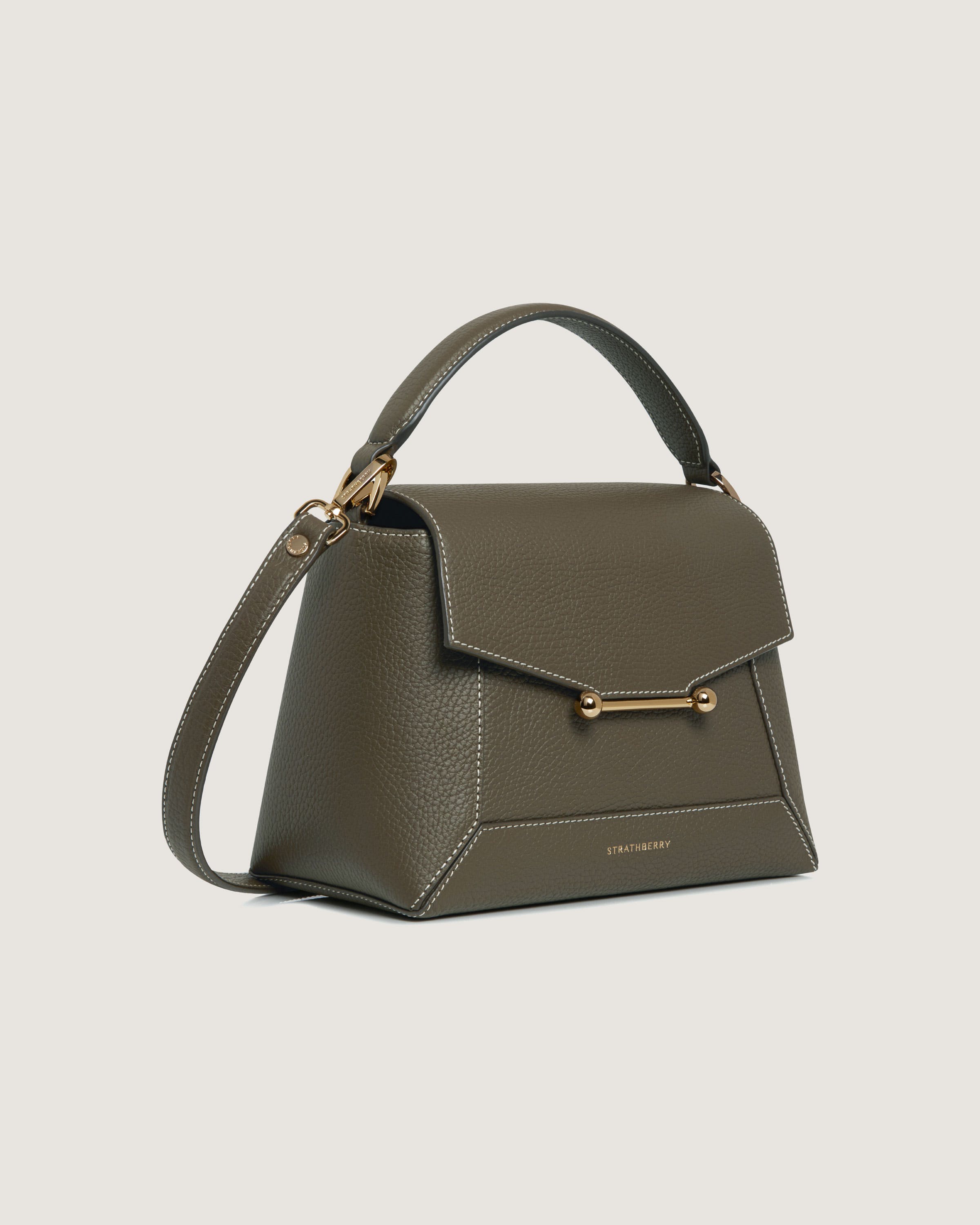 A grey handbag with a gold handle