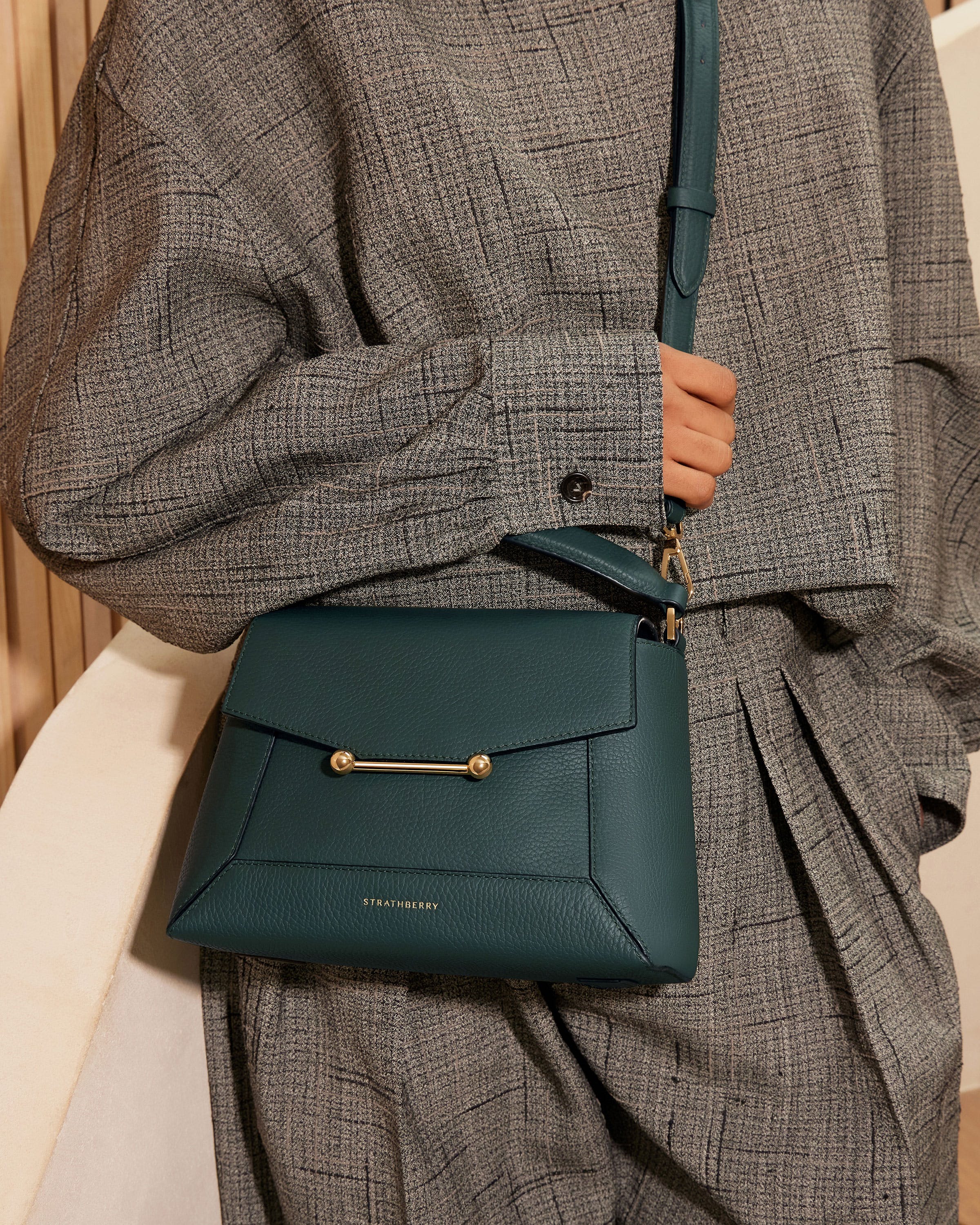 A woman holding a green purse in her hands